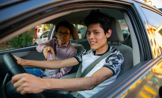 istock Learning to drive. Two young men in a driving session 1291688334