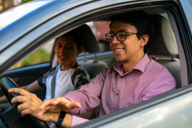 istock Learning to drive. Two young men in a driving session 1291688344