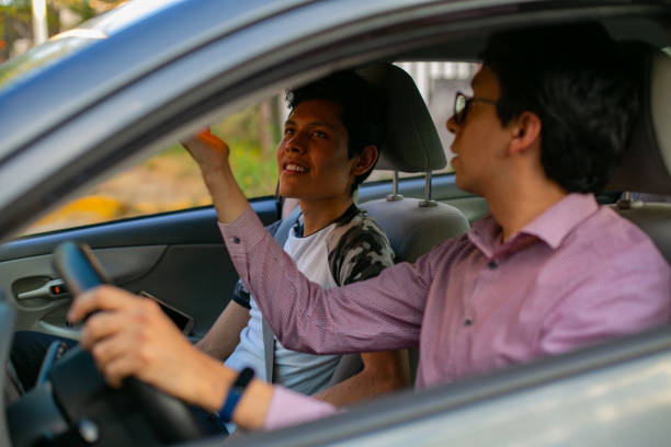 istock Learning to drive. Two young men in a driving session 1291688358