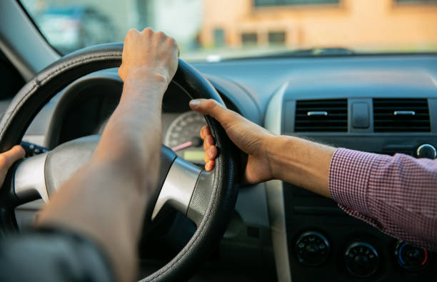 istock Learning to drive. Close up of Two young men in a driving session 1291688376