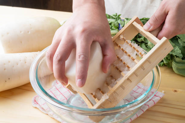 Grating daikon radish with traditional japanese bamboo grator