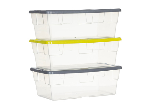 Composition with three transparent plastic boxes with green and gray lids, to store various products on a white background.