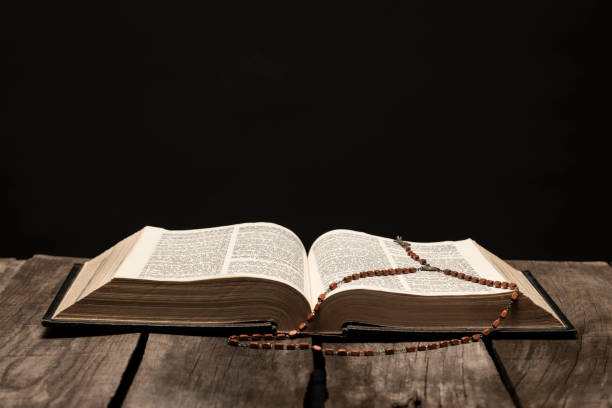 istock Holy Bible open on pedestal on black background 1291692409