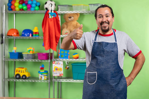 man working in toy store Proud enterprising man in his toy store attending and showing his toy store. Interior detail toy store stock pictures, royalty-free photos & images