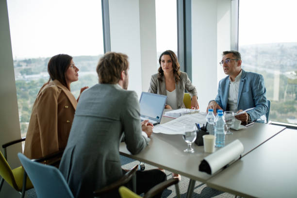 istock Businessman presenting a project on sheet to clients at the conference table 1291716181