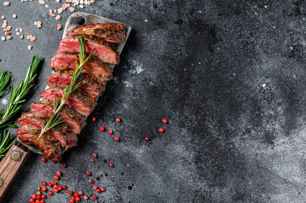 Grilled Vegas strip steak. Marble meat beef. Black background. Top view. Copy space Grilled Vegas strip steak. Marble meat beef. Black background. Top view. Copy space. blade roast stock pictures, royalty-free photos & images