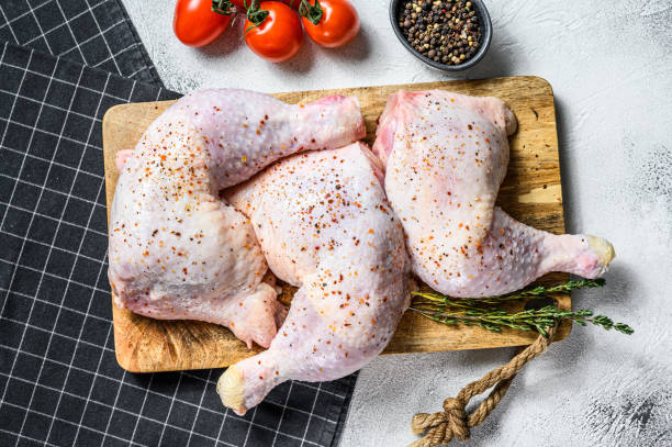 Fresh raw chicken thighs, legs on a cutting Board with spices, cooking. Gray background. Top view. Copy space Fresh raw chicken thighs, legs on a cutting Board with spices, cooking. Gray background. Top view. Copy space. pink pepper spice ingredient stock pictures, royalty-free photos & images