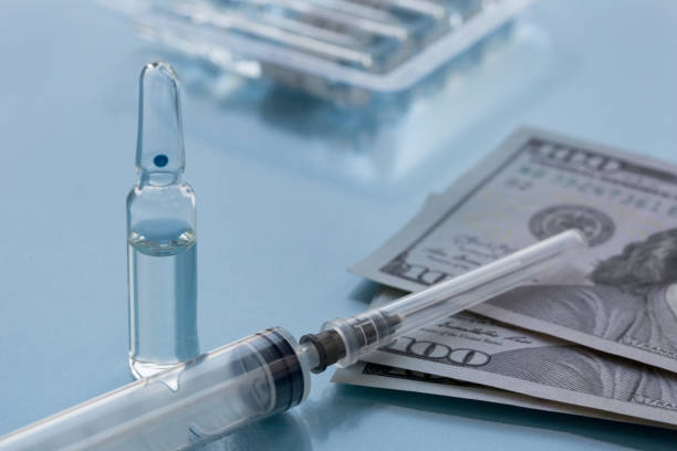 istock Packaging with ampullas, expendable syringe for vaccination and paper money. Coronavirus vaccination concept. Insurance medicine. 1291721888