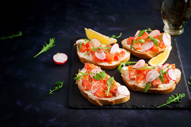 istock Sandwich with salted salmon for healthy breakfast on dark background. Fish menu. 1291725642