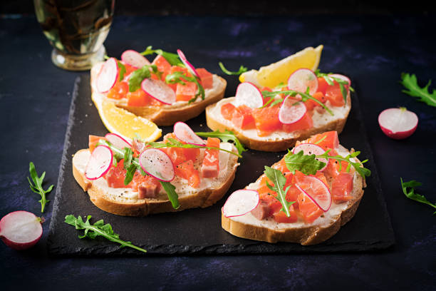 istock Sandwich with salted salmon for healthy breakfast on dark background. Fish menu. 1291725669
