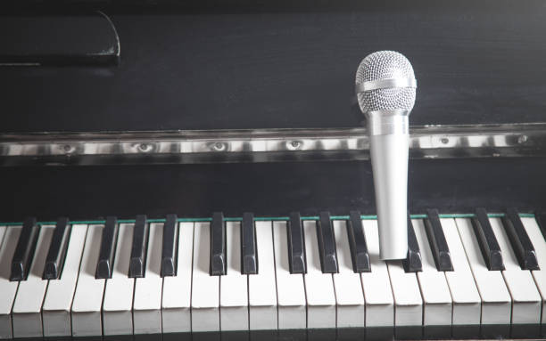 istock Microphone on piano keyboard. White and black. Music 1291728746