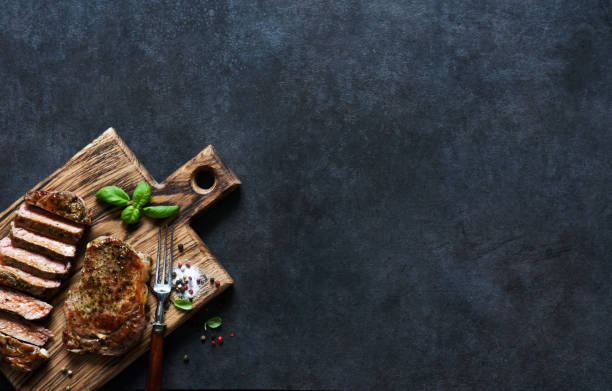 istock Grilled beef steak with herbs and spices. Top view with space to copy text 1291728951