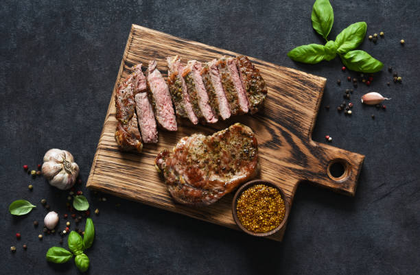 istock Grilled beef steak with herbs and spices. Top view with space to copy text 1291729067