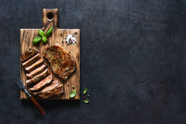 istock Grilled beef steak with herbs and spices. Top view with space to copy text 1291729136