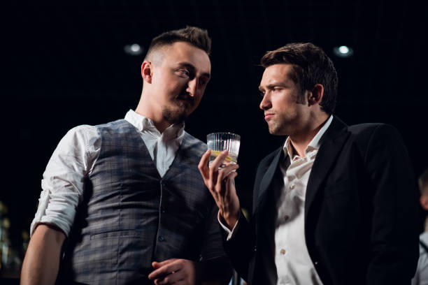 istock Elegant men in a nightclub talking, drinking a cocktail 1291731293