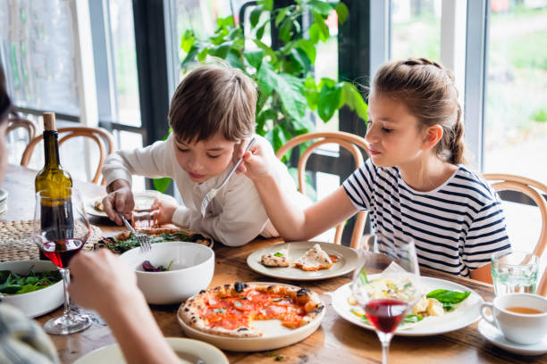 istock Two beautiful kids eating with a appetite 1291731537