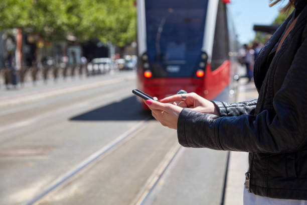 istock Woman using cellphone on a tram station in Europe. 1291734301