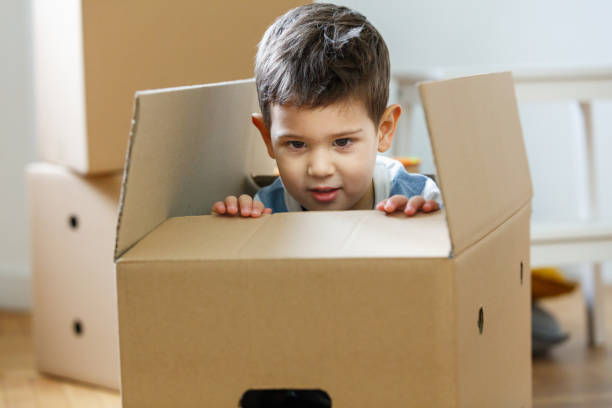 istock Boy sticking out of an empty box during house move 1291737491