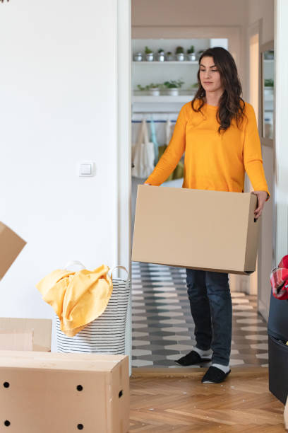 istock Woman holding cardboard box and looking at mess during relocation 1291737831