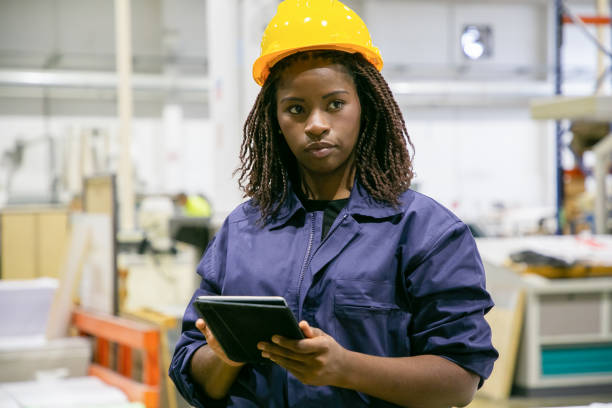 istock Content female plant worker standing with tablet and looking 1291738634