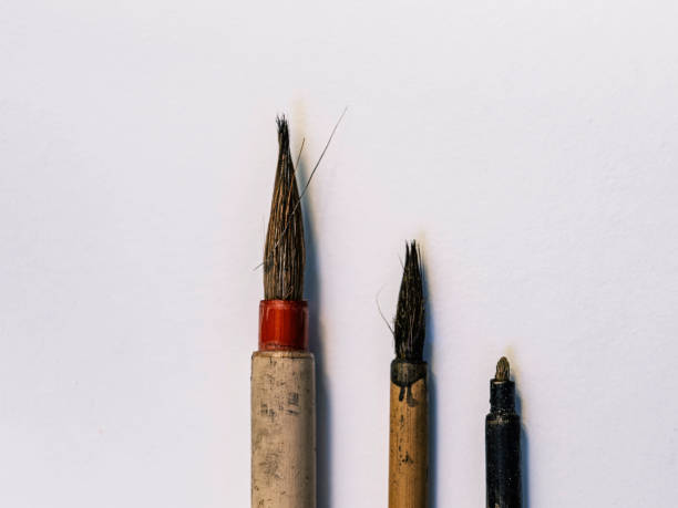 istock Rustic Asian Calligraphy Brushes on Grimy White Paper Background, Closeup Macro Photo 1291739798