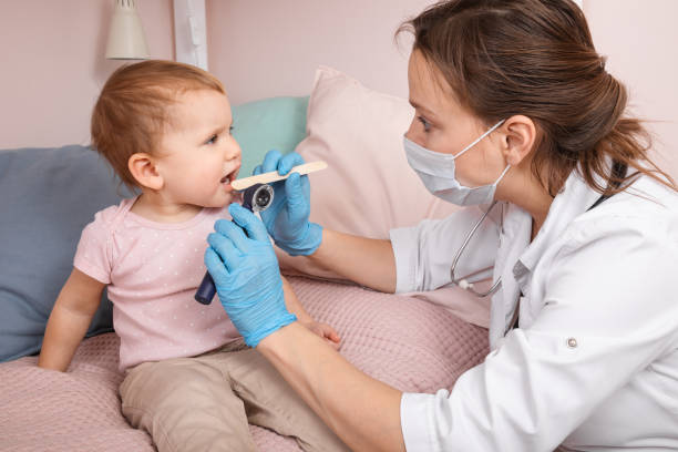 coronavirus kilitleme sırasında evde bebek kız boğaz kontrolü çocuk doktoru - boğaz ağrısı stok fotoğraflar ve resimler