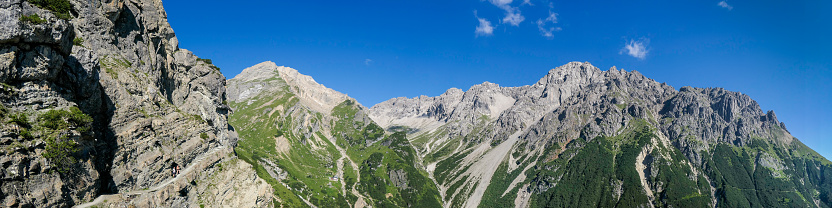 Mountain range north-west of Imst, Austria, showing - amongst others, Muttekopf, Maldonkopf, and Hintere and Vordere Plattein. Two people are hiking on a small path