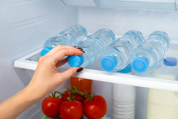 istock Female hand taking bottle of water from a fridge 1291743536