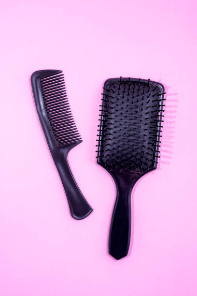 istock Hair brush and Comb on pink background 1291744182