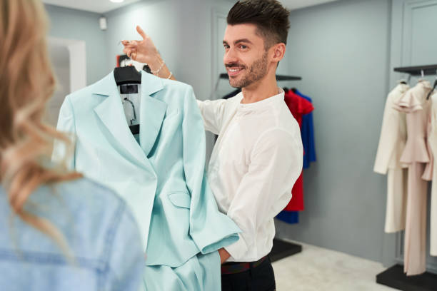 istock Man offering a suit from the new collection 1291746940