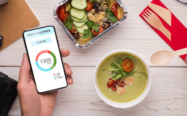 istock Healthy Eating. Man Using Calories Counting App On Smartphone And Having Lunch 1291747285