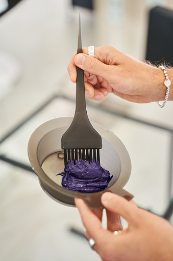 Hair stylist with hair samples of violet color. Hair dye in the hands of a hairdresser. Beauty care, hairstyling, fashion, lifestyle glamour concept