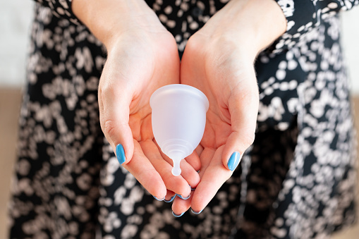 Copa menstrual en manos de una mujer de cerca photo