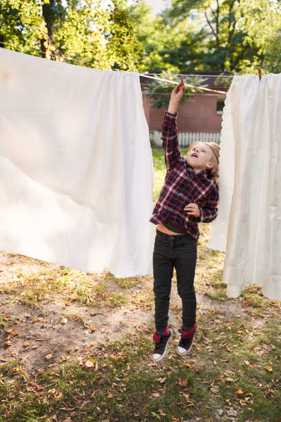istock Boy clings a clothespin to a rope 1291751388