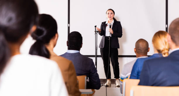 istock Confident female lecturer speaking to businesspeople at seminar 1291753620