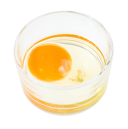 raw egg in glass bowl isolated on white background
