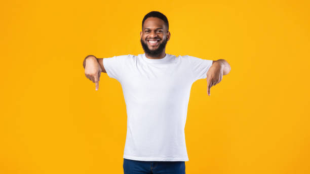 istock African Guy Pointing Fingers Down Advertising Something Over Yellow Background 1291754795