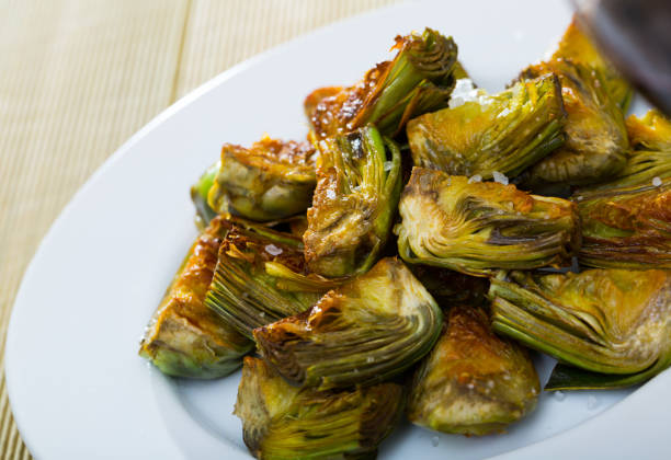 istock Appetizing artichokes fried in oil 1291754858