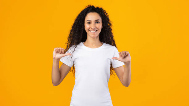 istock Happy Lady Pointing Thumbs At Herself Posing On Yellow Background 1291754868