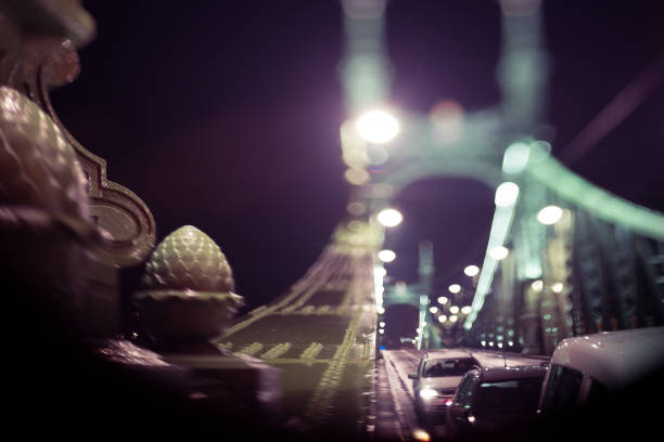 cars driving over a bridge at night, out-of focus nice bokeh lights, selective focus