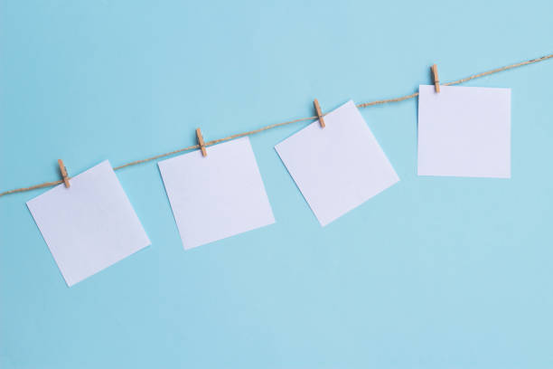 istock four blank note papers attached to a rope on blue background 1291756631