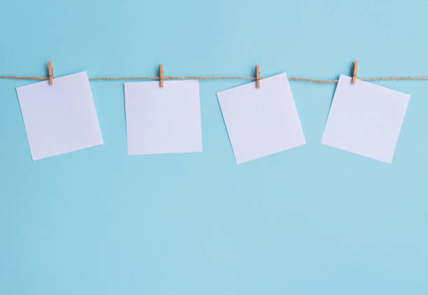 istock four blank note papers attached to a rope on blue background 1291756755