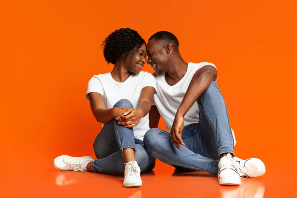 istock Emotional black lovers cuddling on orange background 1291759644