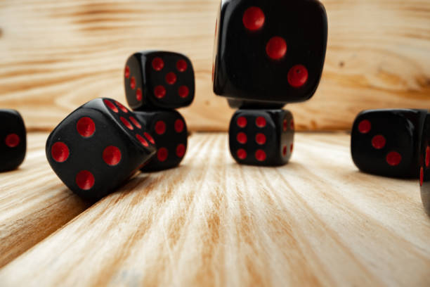 istock Macro of black tossed dice on wooden background 1291760094