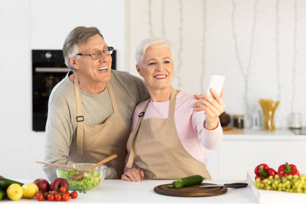 istock Joyful Elderly Spouses Making Selfie Having Fun Cooking In Kitchen 1291760116