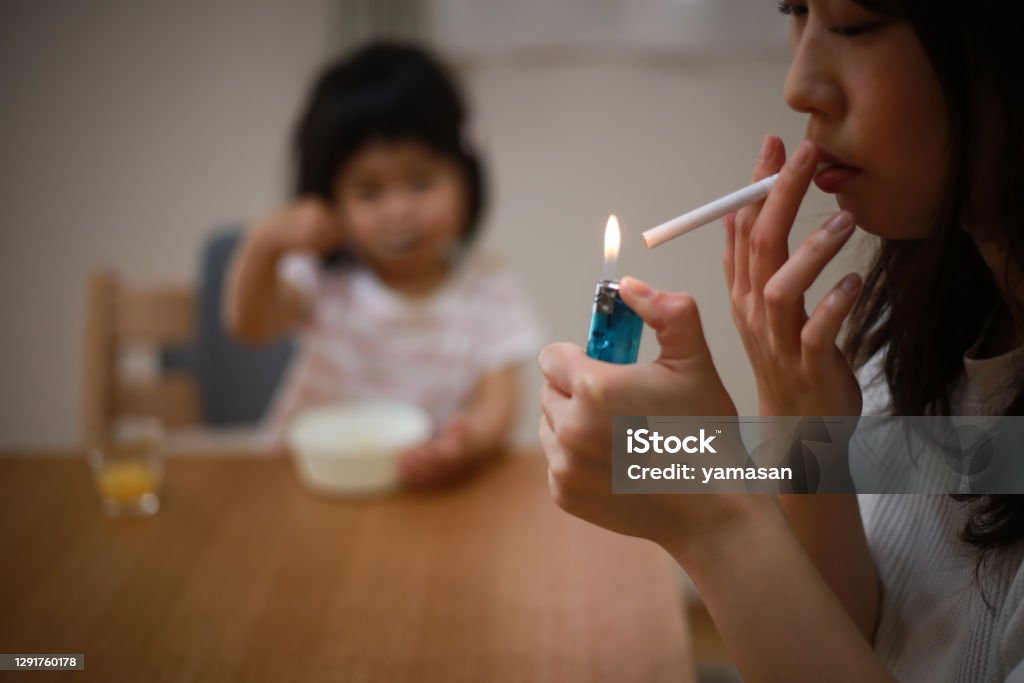 Mother smoking near children Passive Smoking Stock Photo