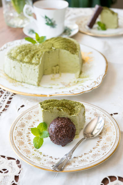 istock Matcha cheese cake slice , chocolate and sterling siver spoon on antique plate 1291760262