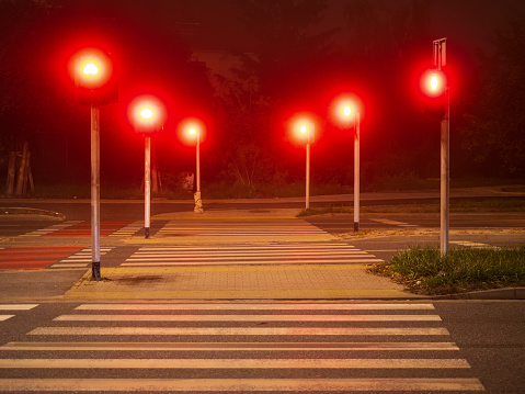 crosswalk and red light of traffic lights in a night city