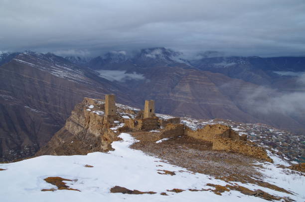 au bord de la falaise. vue du canyon et de la rivière, de la chaîne de montagnes et de l’ancien aul goor avec des tours défensives et militaires. nature et voyage. - russia river landscape mountain range photos et images de collection