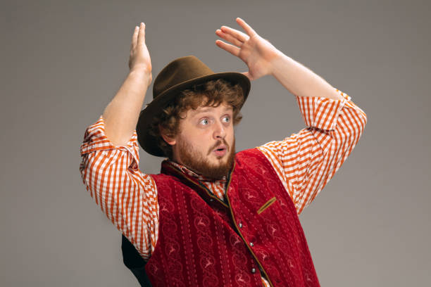 istock Happy smiling man dressed in traditional Austrian or Bavarian costume gesturing isolated on grey studio background 1291763834